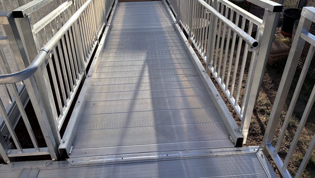 Aluminum accessibility ramp with handrails on a manufactured home replacement project