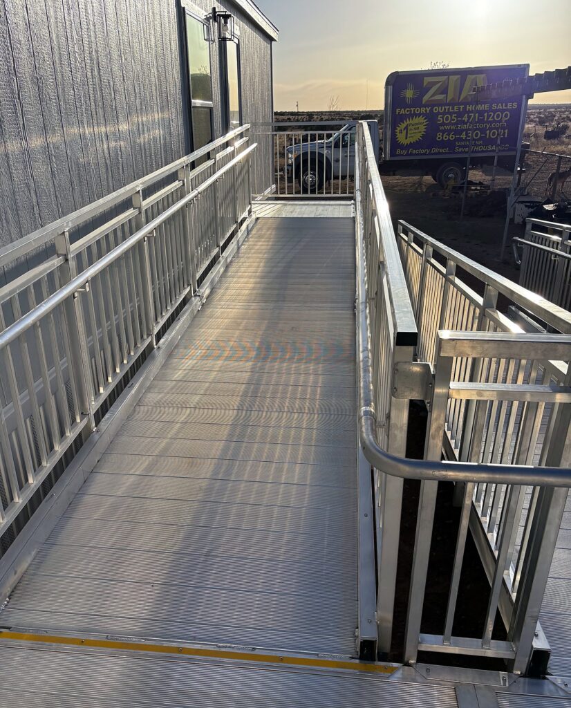 Accessible ramp at a new manufactured home, with a Zia Factory Outlet truck on site